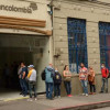 Gente hace fila afuera de una oficina de Bancolombia en el centro de Manizales.