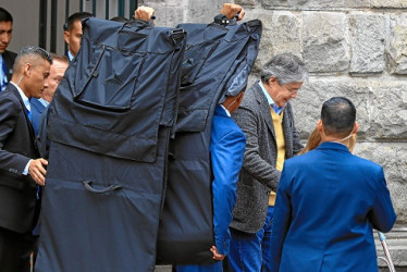 El presidente de Ecuador, Guillermo Lasso, sale protegido con mantas antibalas del Centro Cultural Metropolitano, en Quito (Ecuador).