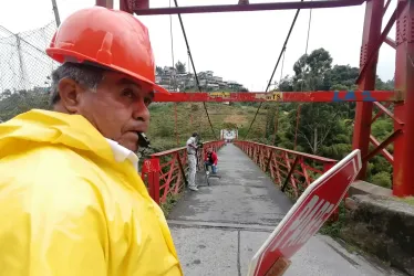 En el puente Olivares hay una persona regulando el paso de vehículos. 