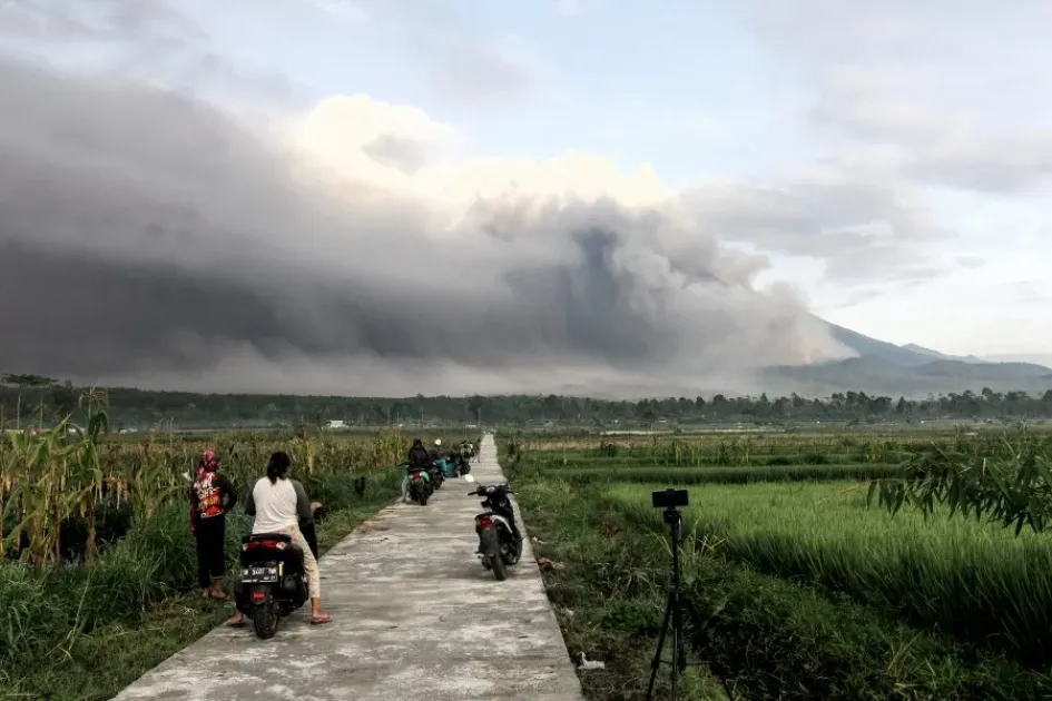 El Monte Semeru arroja materiales volcánicos al aire mientras la gente observa durante una erupción en Lumajang, Java Oriental, Indonesia. El Monte Semeru arroja materiales volcánicos al aire mientras la gente observa durante una erupción en Lumajang, Java Oriental, Indonesia.