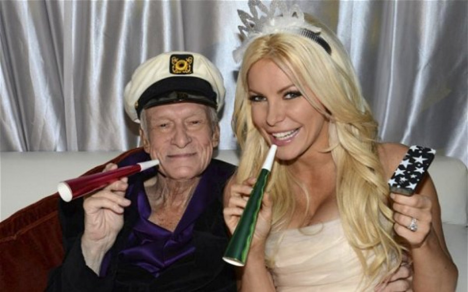 Los-hombres-que-más-sexo-han-tenido-en-la-historia Hugh Hefner con una conejita Playboy sentados en un sofá