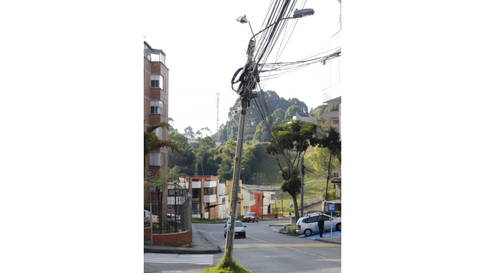 En la esquina de la carrera 28A con calle 67, en el barrio Palermo, está este poste torcido lleno de cables. En ese mismo sector hay otros dos inclinados. En la esquina de la carrera 28A con calle 67, en el barrio Palermo, está este poste torcido lleno de cables. En ese mismo sector hay otros dos inclinados.