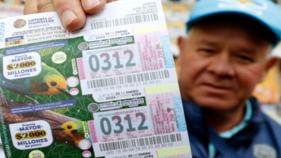 loteria-de-manizales-resultados-22-febrero-2023 Vendedor de Lotería de Manizales muestro sus tiquetes.