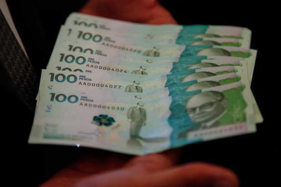 Ya-llego-mi-giro Dos manos sosteniendo billetes de 100 mil pesos Colombianos
