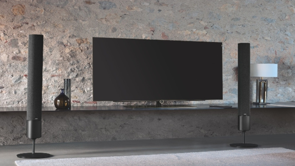 Mejores-teatros-en-casa TV con parlantes al lado frente a una pared.
