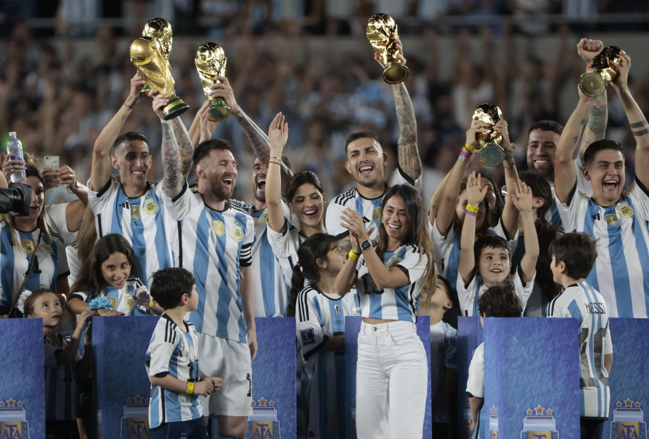 Lionel Messi (adelante, a la izquierda), acompañado de su esposa Antonela Roccuzzo y sus hijos, encabezó la celebración argentina, en la que los jugadores levantaron el trofeo de la Copa Mundo ante su hinchada, en la primera presentación de la Selección como tricampeona tras la obtención del título en Qatar 2022. Lionel Messi (adelante, a la izquierda), acompañado de su esposa Antonela Roccuzzo y sus hijos, encabezó la celebración argentina, en la que los jugadores levantaron el trofeo de la Copa Mundo ante su hinchada, en la primera presentación de la Selección como tricampeona tras la obtención del título en Qatar 2022.