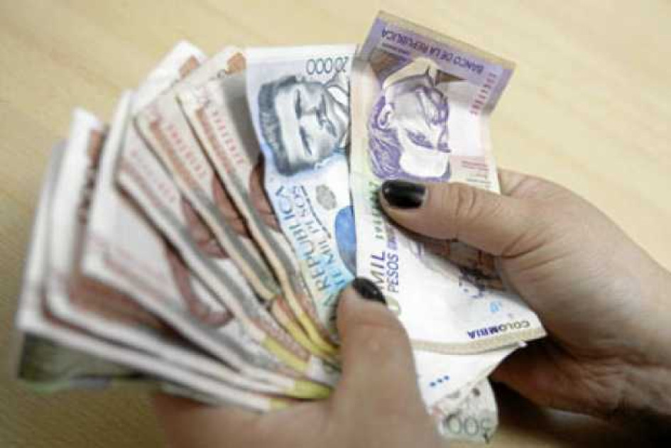 Carreras-peor-pagadas-en-Colombia Persona contando billetes de pesos colombianos.
