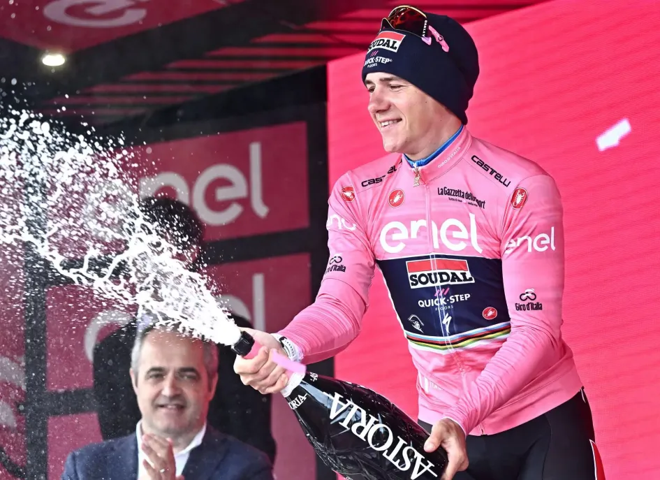 El belga Remco Evenepoel del equipo Soudal Quick-Step celebra en el podio vistiendo el maillot rosa de líder general después de ganar la novena etapa de la carrera ciclista Giro de Italia 2023, una contrarreloj individual de 35 km desde Savignano sul Rubicone hasta Cesena, Italia. El belga Remco Evenepoel del equipo Soudal Quick-Step celebra en el podio vistiendo el maillot rosa de líder general después de ganar la novena etapa de la carrera ciclista Giro de Italia 2023, una contrarreloj individual de 35 km desde Savignano sul Rubicone hasta Cesena, Italia.