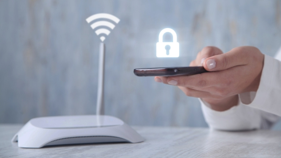 Cómo-proteger-mi-red-wifi-de-hackers Mujer conecta su celular a wifi al lado del router.