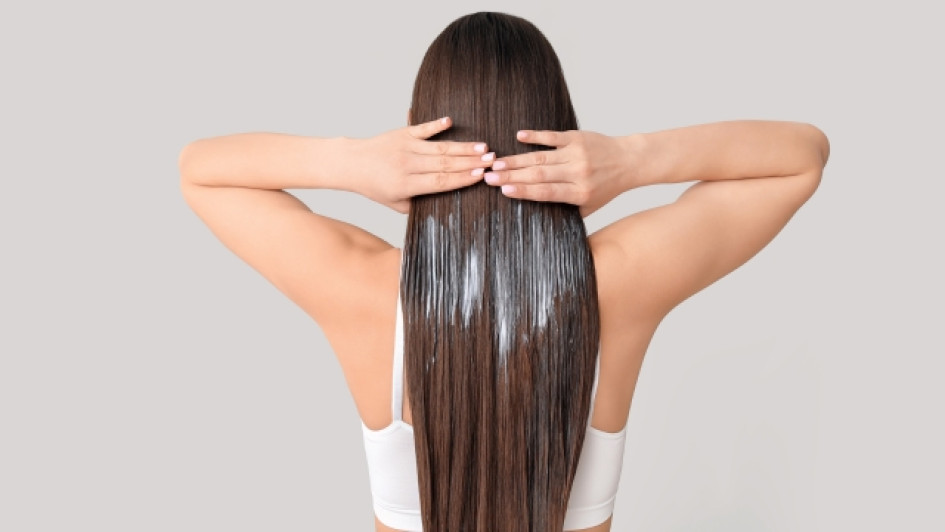 Para-que-sirve-la-linaza-en-el-cabello Mujer de espalda se pasa las manos por su cabello castaño