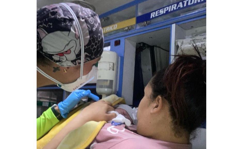 El bebé recién nacido junto a su madre y personal de salud. Bebé nació dentro de una ambulancia del ByR en Manizales
