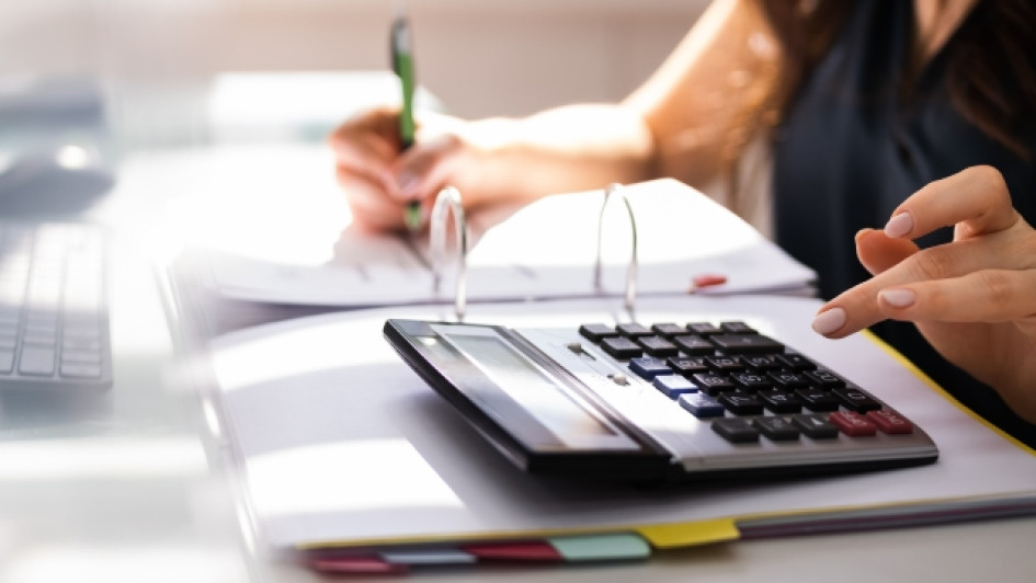 Que-es-reteica-y-cuando-se-aplica Mujer en un escritorio con un cuaderno y una calculadora.