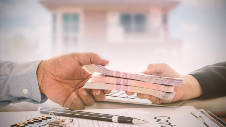 Prestamos-en-linea-para-reportados Mano pasando un fajo de billetes a otra mano.
