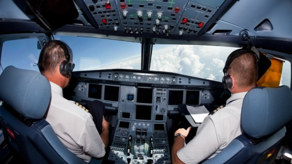 Cuanto-gana-un-piloto-en-Colombia. Cabina de un avión en el aire con piloto y copiloto adentro.