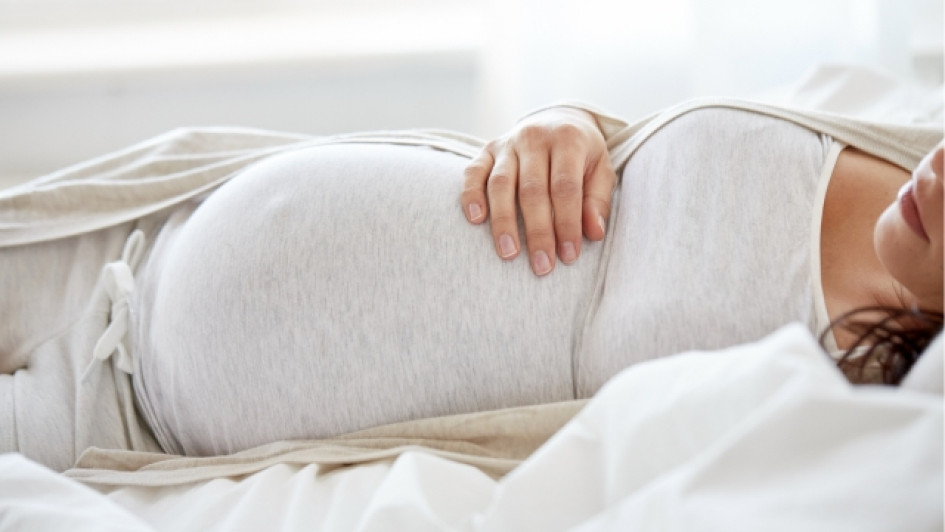 Como-debe-dormir-una-mujer-embarazada Mujer embarazada acostada en una cama.