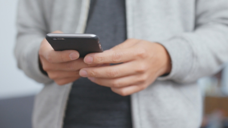 Como-saber-mi-numero-movistar Hombre sosteniendo un celular con ambas manos.