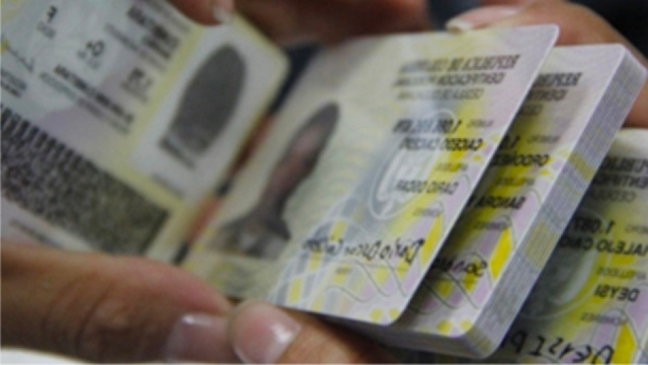 Como-verificar-una-cedula-colombiana Persona con muchas cédulas de ciudadanía colombianas en las manos.