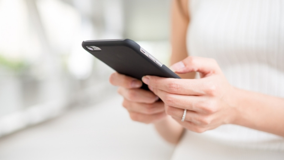 Como-saber-mi-numero-WOM Mujer sosteniendo su teléfono celular.