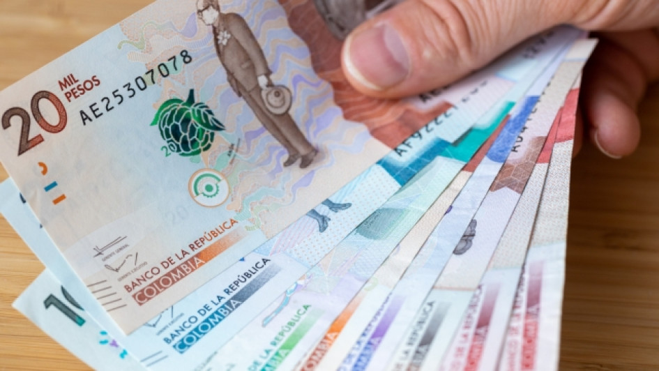 Como-saber-si-un-vehiculo-debe-impuestos-de-anos-anteriores Dedos sosteniendo varios billetes de pesos colombianos