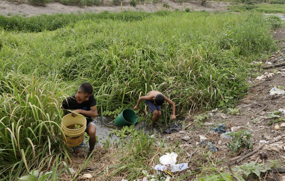 Dos personas recolectan agua de un arroyo, el 27 de marzo, en Guataca, corregimiento de Santa Cruz de Mompox (Bolívar). Dos personas recolectan agua de un arroyo, el 27 de marzo, en Guataca, corregimiento de Santa Cruz de Mompox (Bolívar).