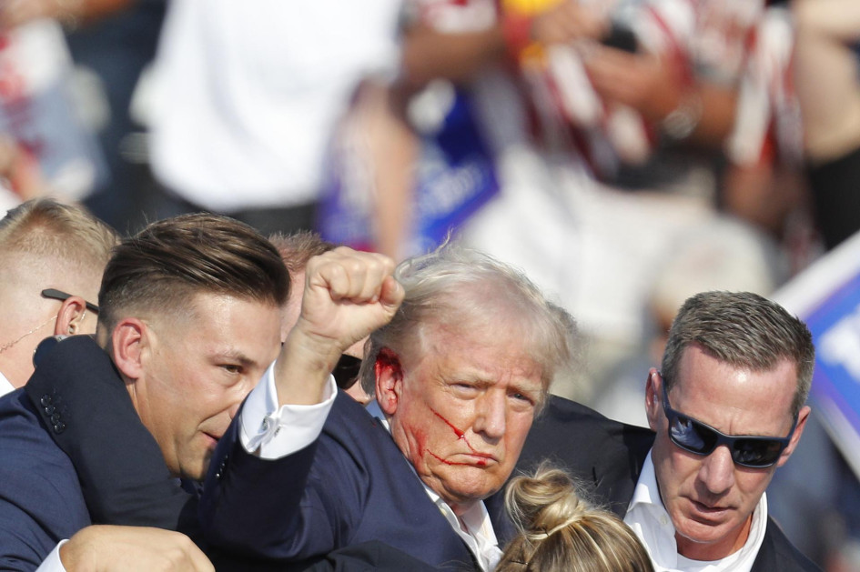 El expresidente estadounidense Donald Trump es sacado del escenario por el servicio secreto después de un incidente durante un mitin de campaña en el Butler Farm Show Inc. en Butler, Pensilvania, EE.UU. Su oreja derecha se ve ensangrentada. El expresidente estadounidense Donald Trump es sacado del escenario por el servicio secreto después de un incidente durante un mitin de campaña en el Butler Farm Show Inc. en Butler, Pensilvania, EE.UU. Su oreja derecha se ve ensangrentada.