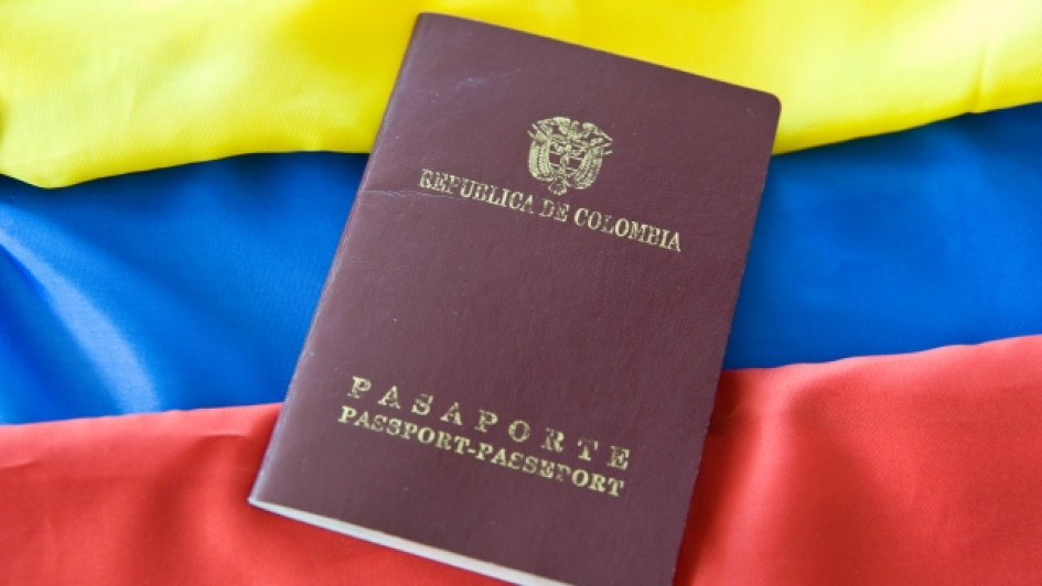 a-que-paises-puedo-viajar-con-pasaporte-colombiano Pasaporte colombiano con una bandera colombiana detrás