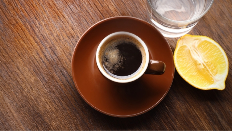 Para-que-sirve-el-cafe-con-limon Taza de café al lado de medio limón