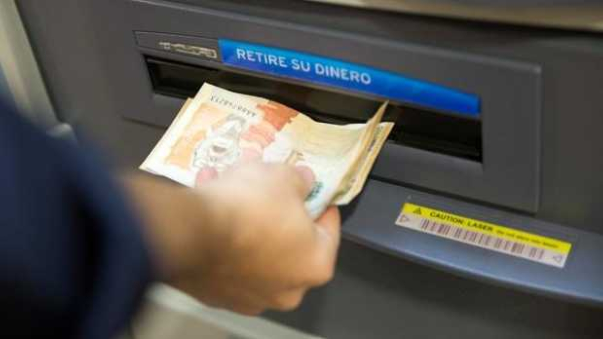 Persona sacando dinero de un cajero electrónico.